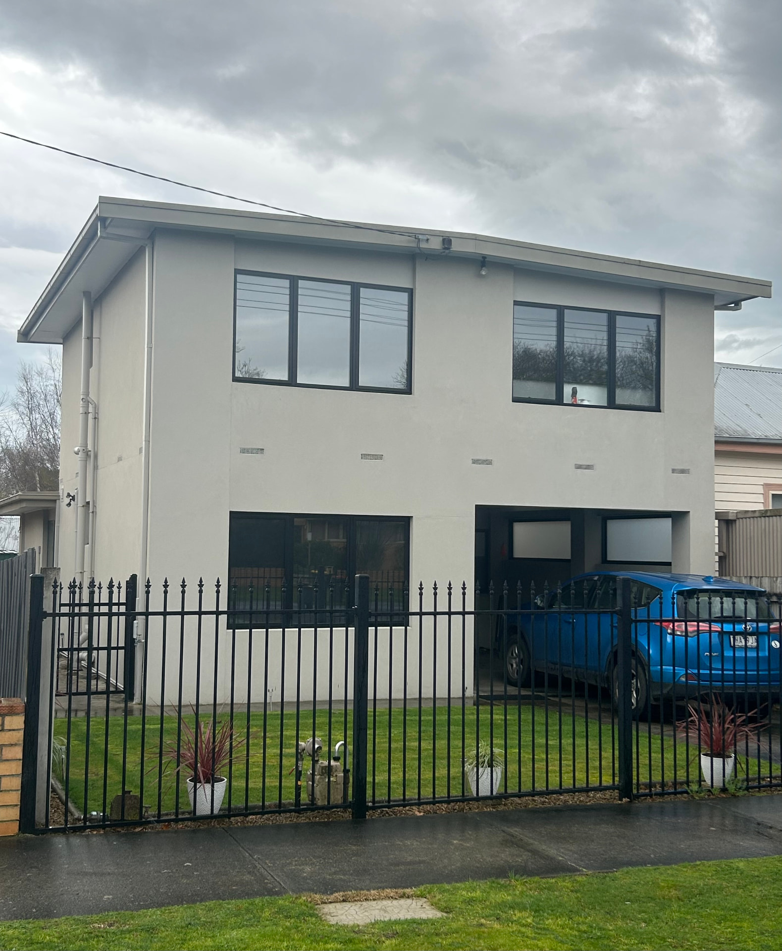 Rendered two storey home with black window frames
